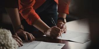 two people writing on paper