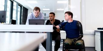 three people looking at a computer screen