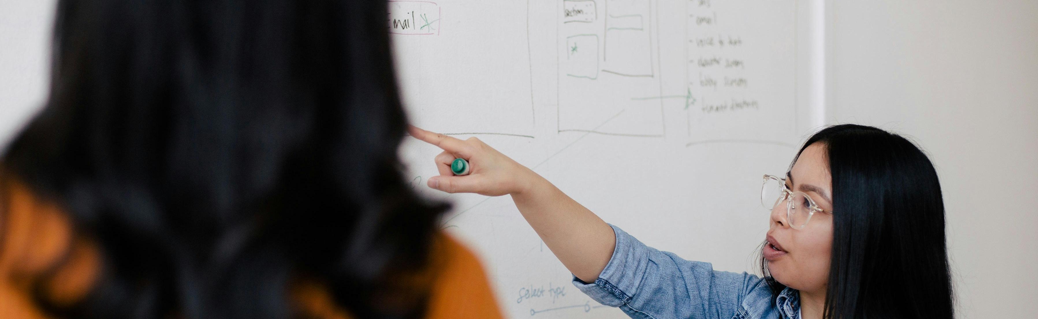 Professor pointing at a white board